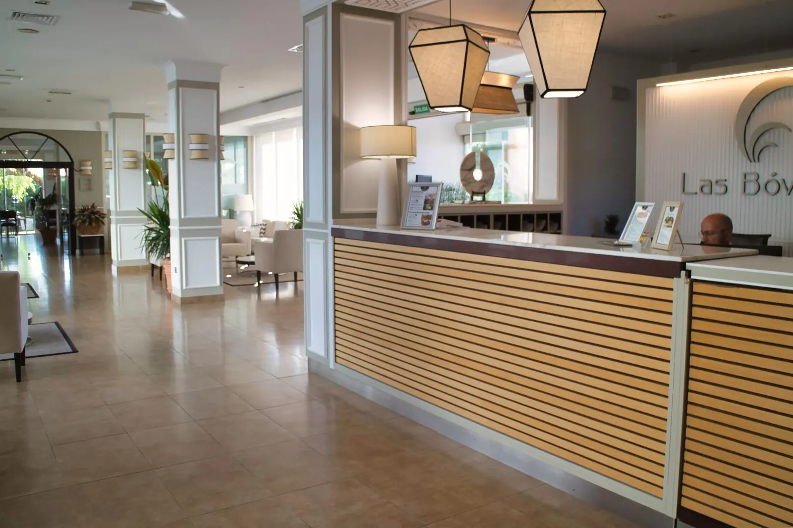 Recepción y zonas comunes del Hotel Las Bóvedas con sillones claros y plantas