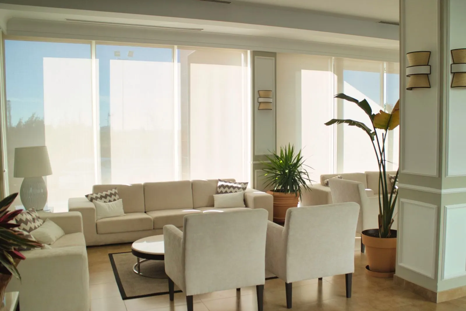 Recepción y zonas comunes del Hotel Las Bóvedas con sillones claros y plantas