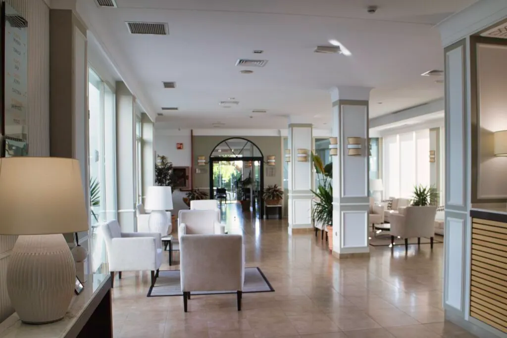Recepción y zonas comunes del Hotel Las Bóvedas con sillones claros y plantas