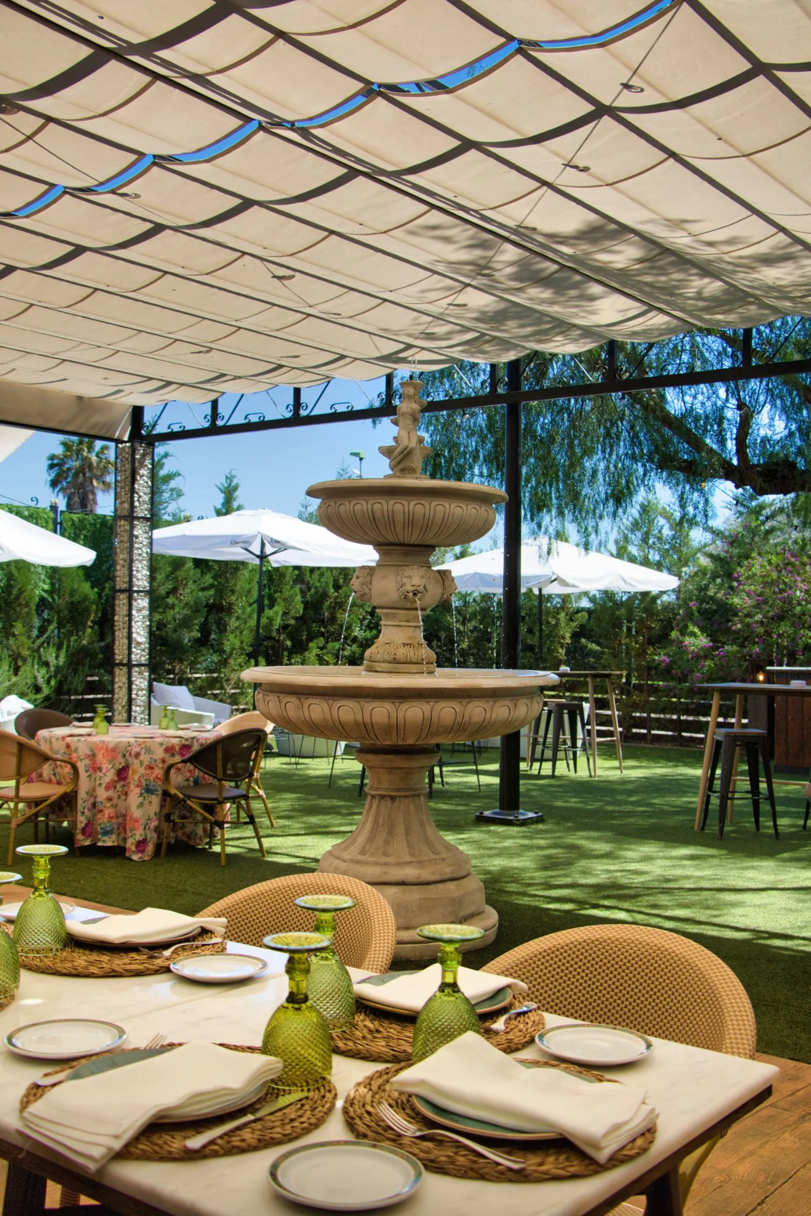 Terraza de Las Bóvedas con fuente, pérgola y mesas con manteles de flores
