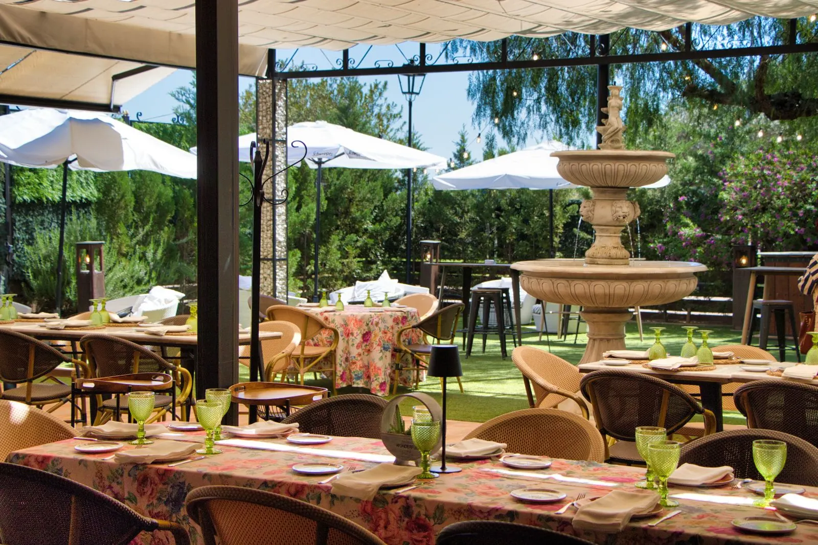 Terraza de Las Bóvedas con fuente, pérgola y mesas con manteles de flores