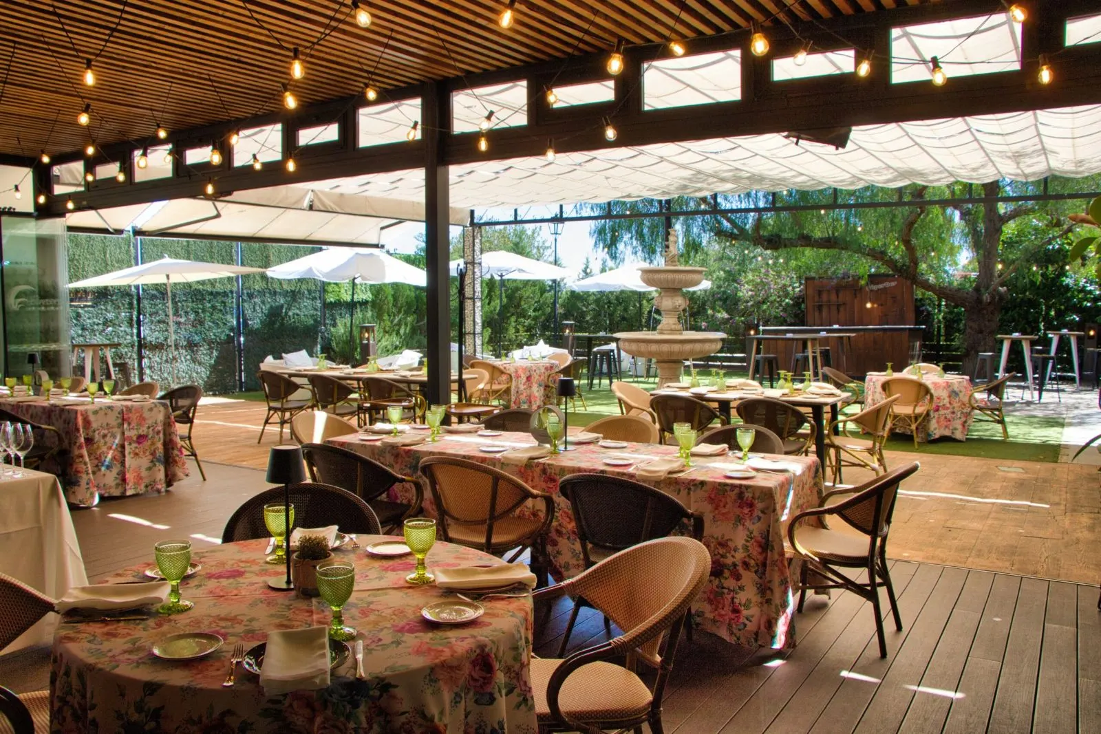 Terraza de Las Bóvedas con fuente, pérgola y mesas con manteles de flores