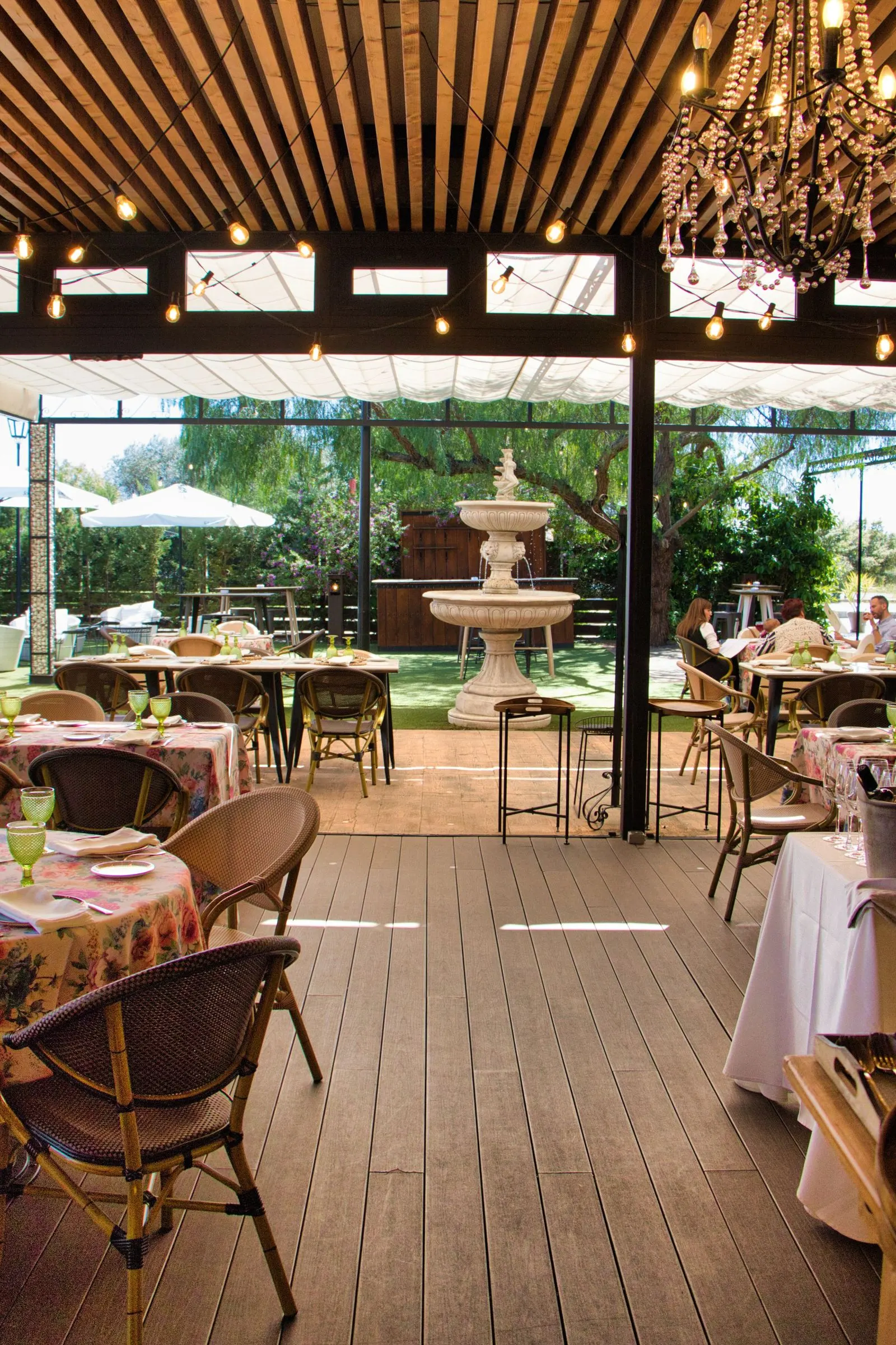 Terraza de Las Bóvedas con fuente, pérgola y mesas con manteles de flores