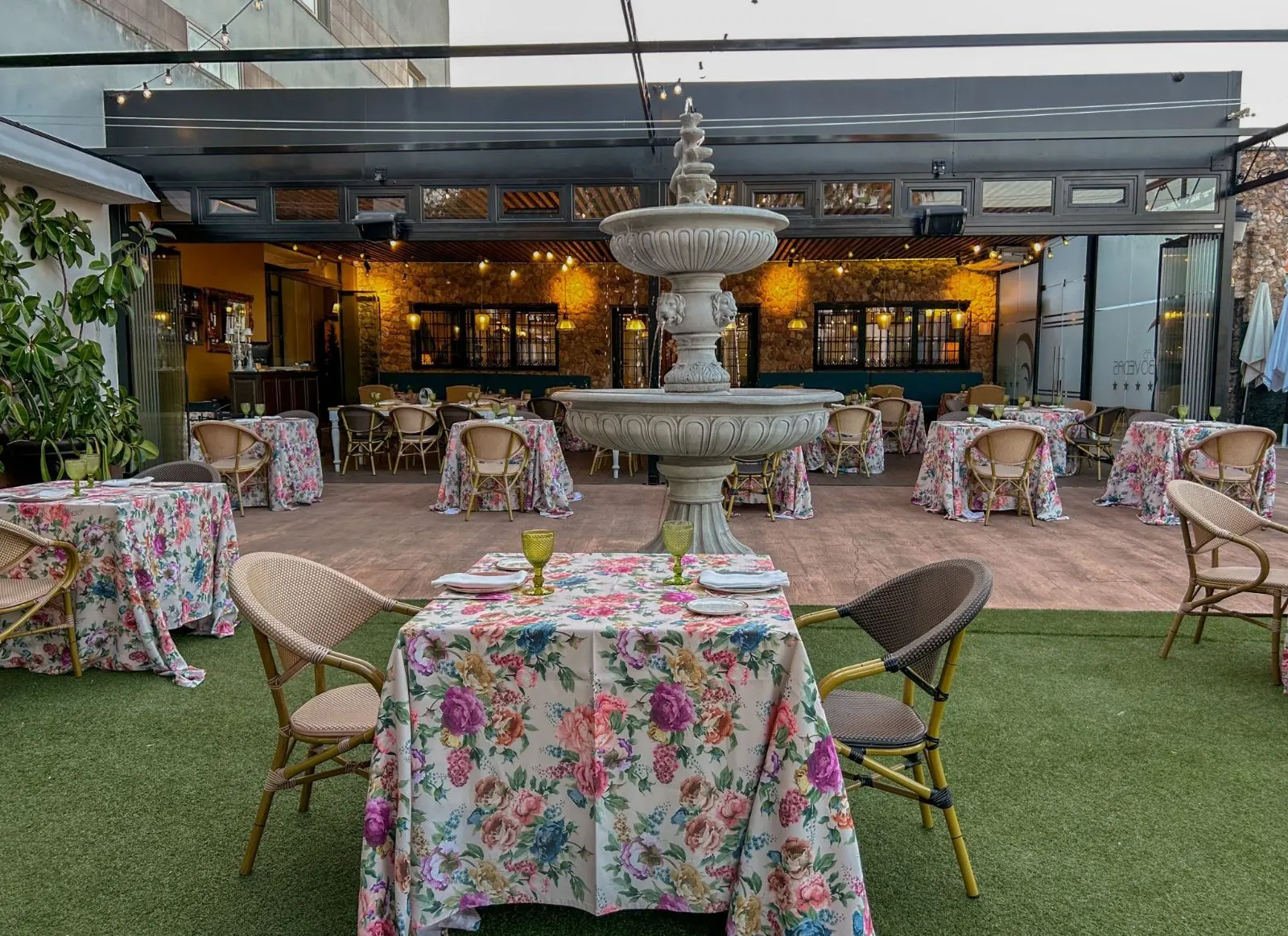 Terraza de Las Bóvedas con fuente, pérgola y mesas con manteles de flores