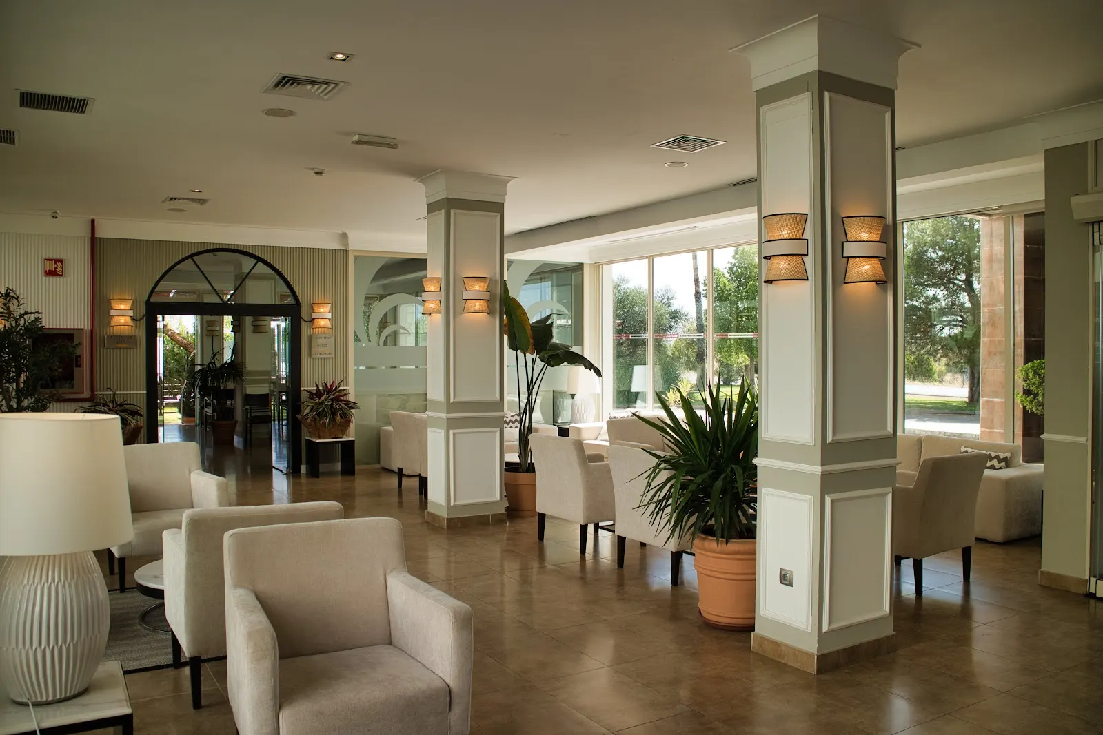 Zona de estar del hall del Hotel Las Bóvedas con columnas y luz natural